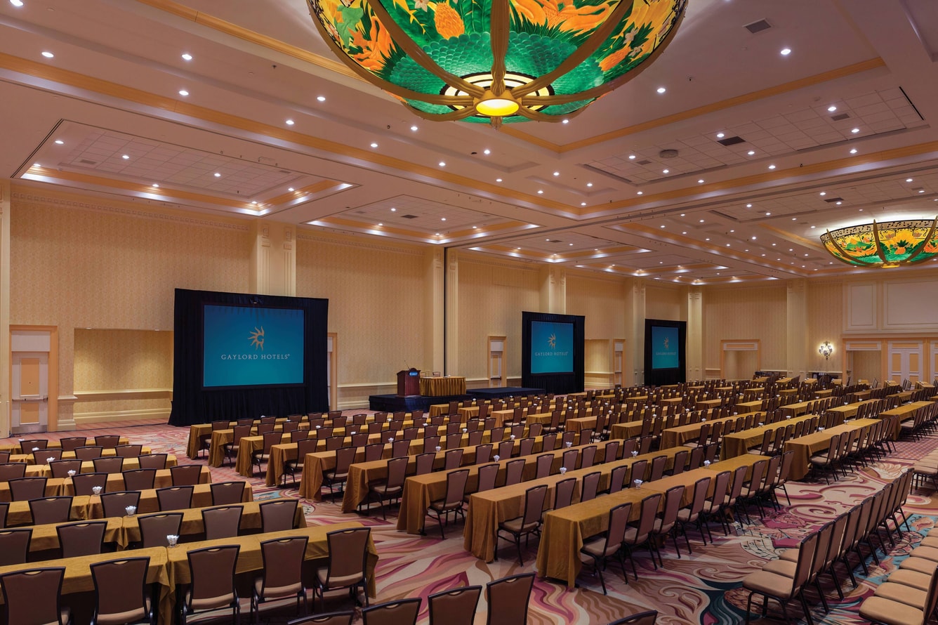 Large ballroom with projector screens and classroom seating