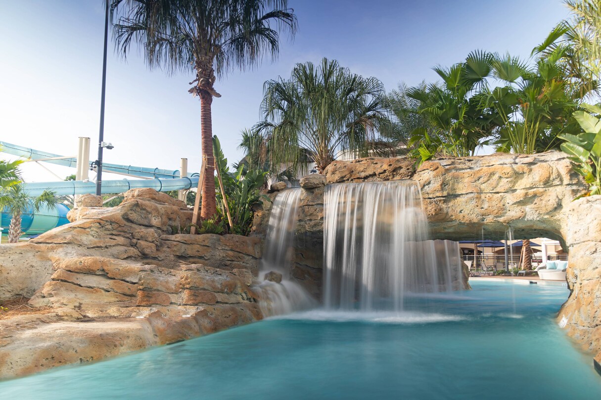 Waterfall flowing over river ride archway.