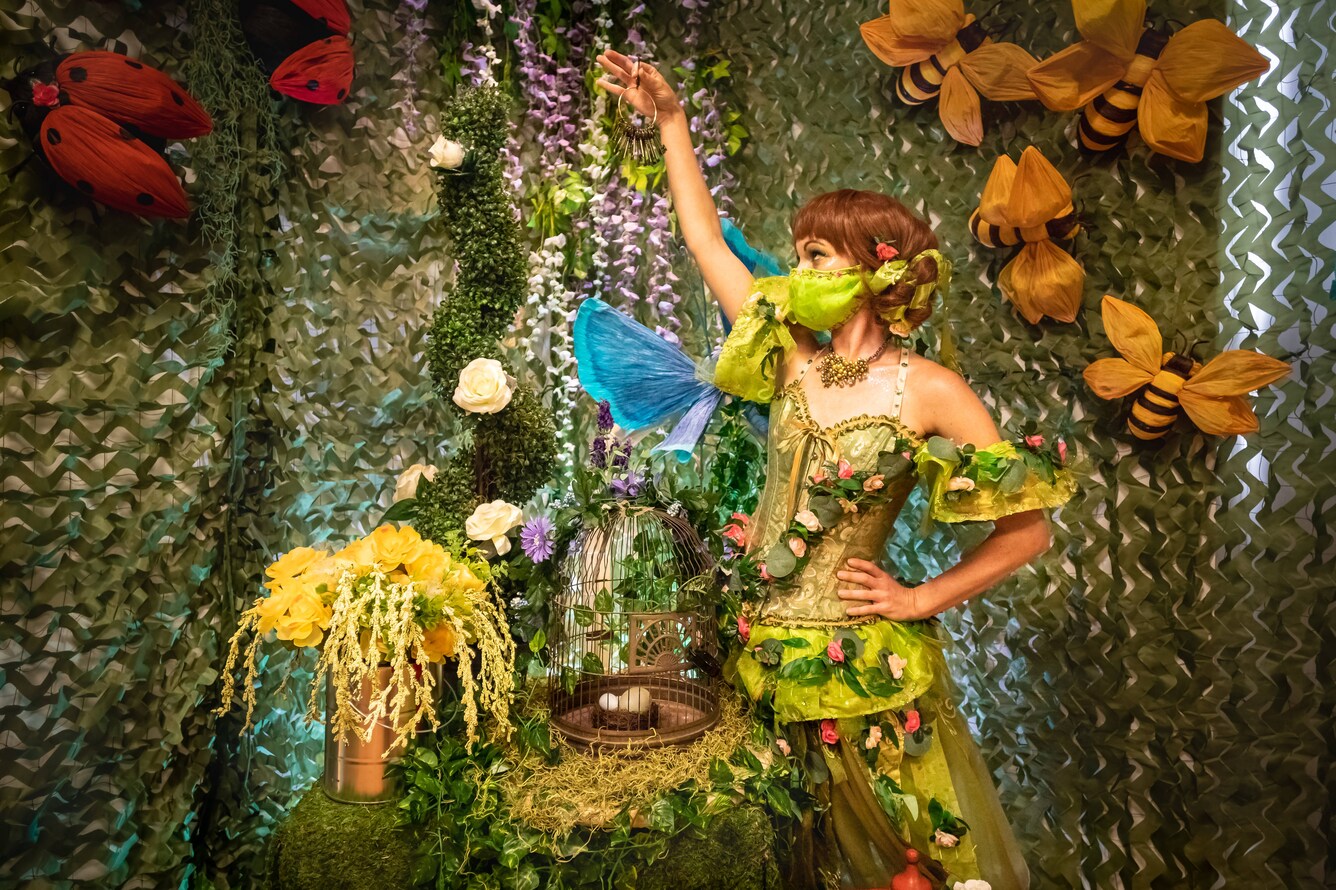 Woman in costume holding bird cage