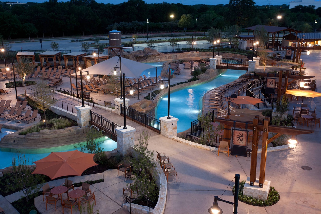 Lazy river at night with pool lights and lounge chairs