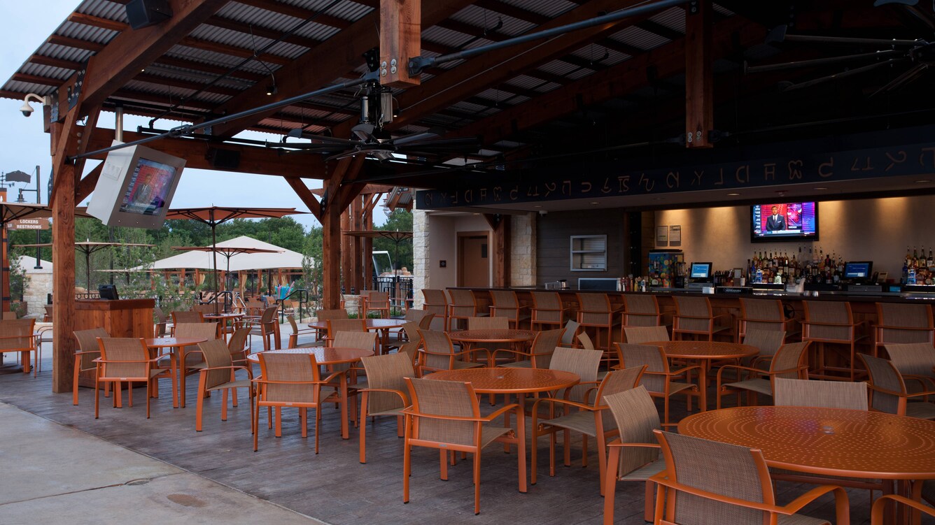 Paradise springs resort pool bar and grill with round tables and shaded awning