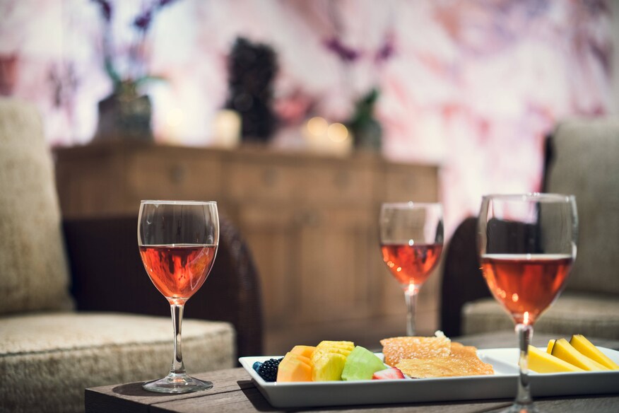 Glasses of whine and fruit plate laid out on a coffee table