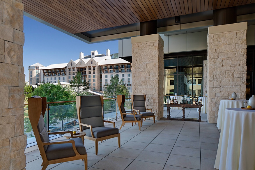 Outdoor terrace event setup with bar and cocktail tables
