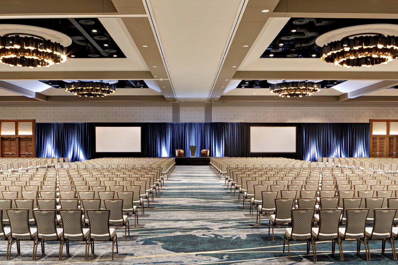 A view of the stage of the Colorado Ballroom with the ballroom floor filled with chairs.