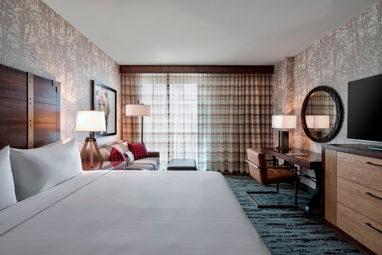 Guest room with a single king bed, sofa and assorted bedroom furniture.