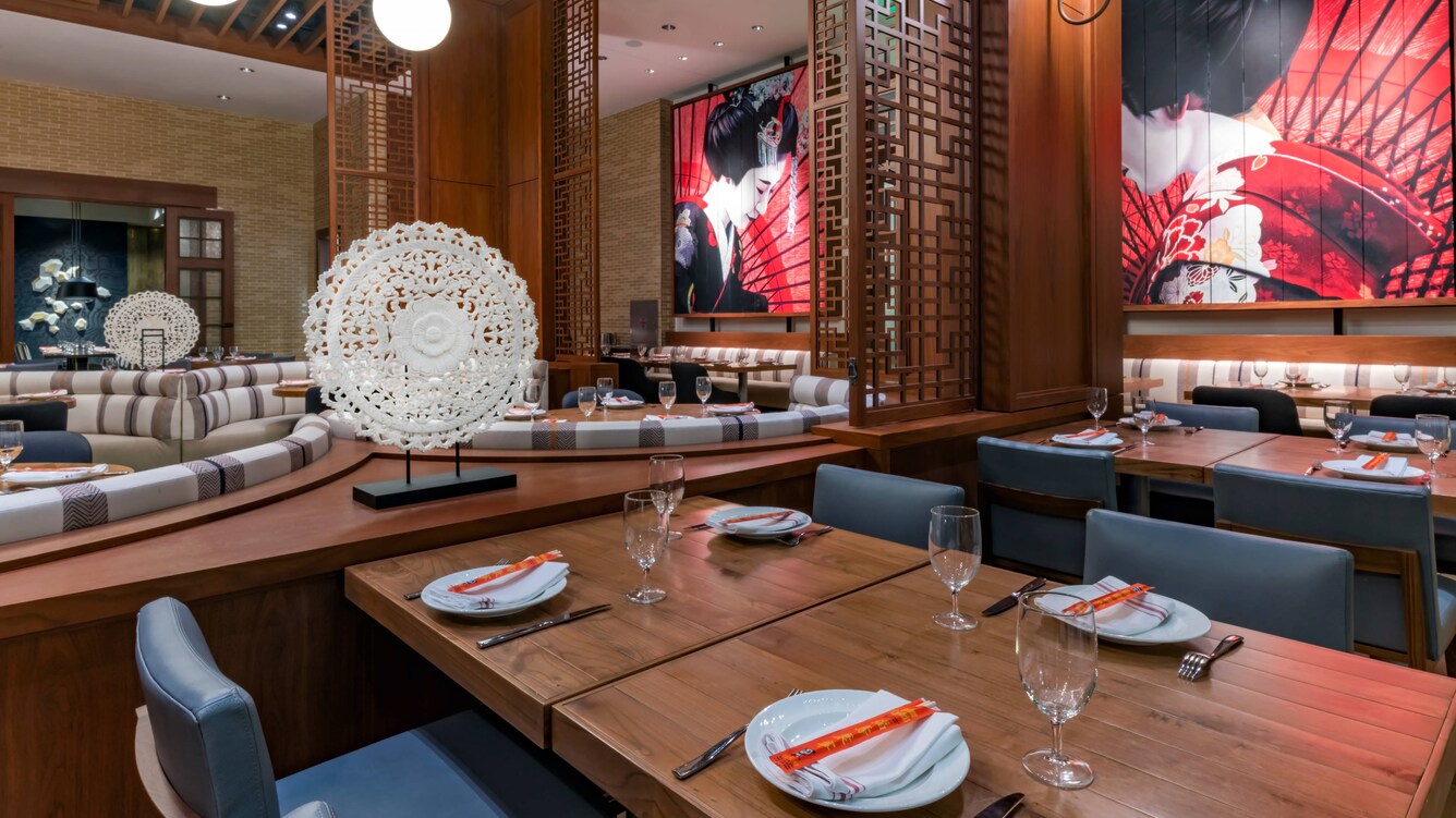 Dining area tables and seating with plates and tableware.