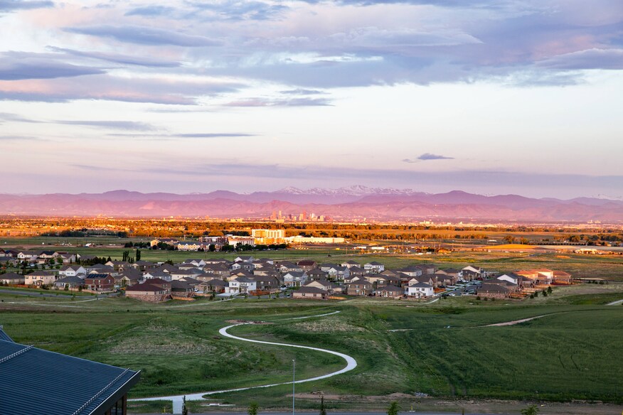 Surrounding landscape and nearby residential area with mountains in the background.