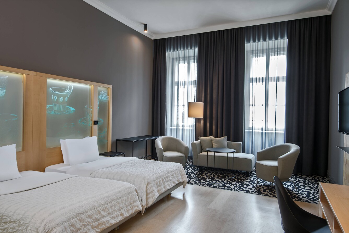 two beds with sitting area and windows
