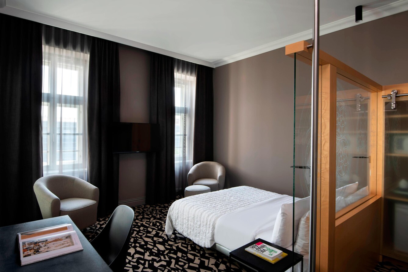 guest room with sitting area, desk and nearby window