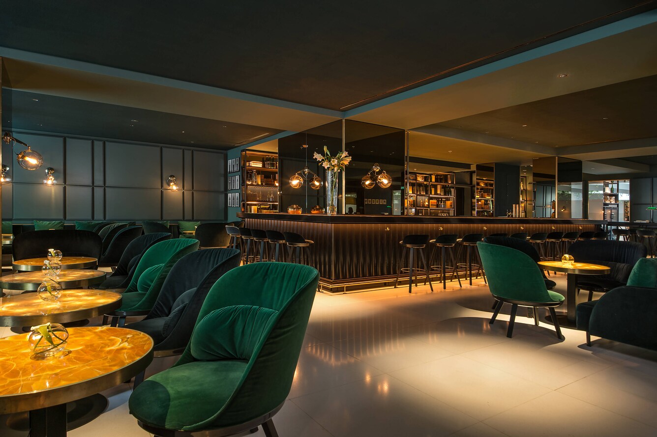 bar area with tables and green chairs