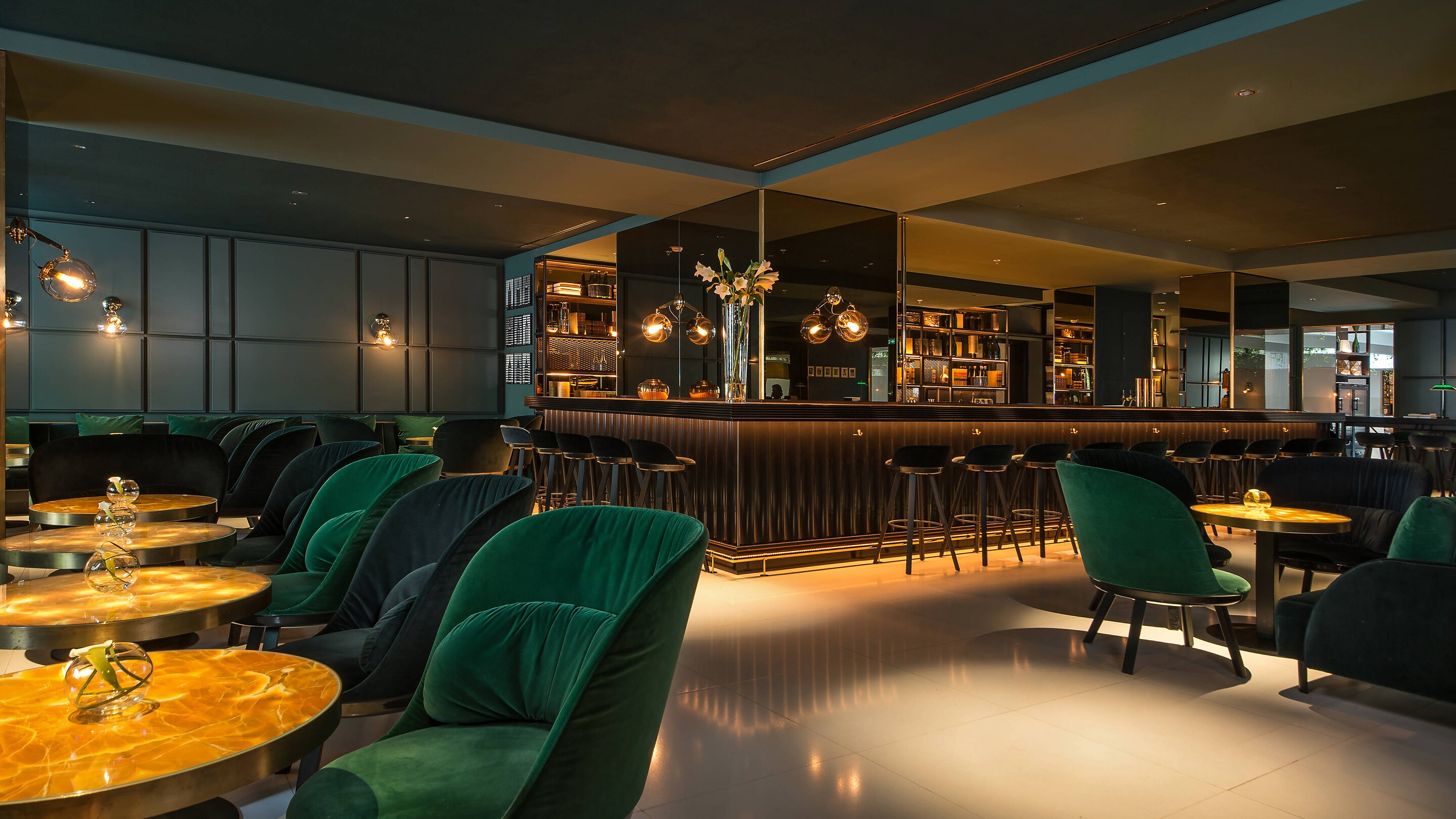 view of bar from golden table with green chairs