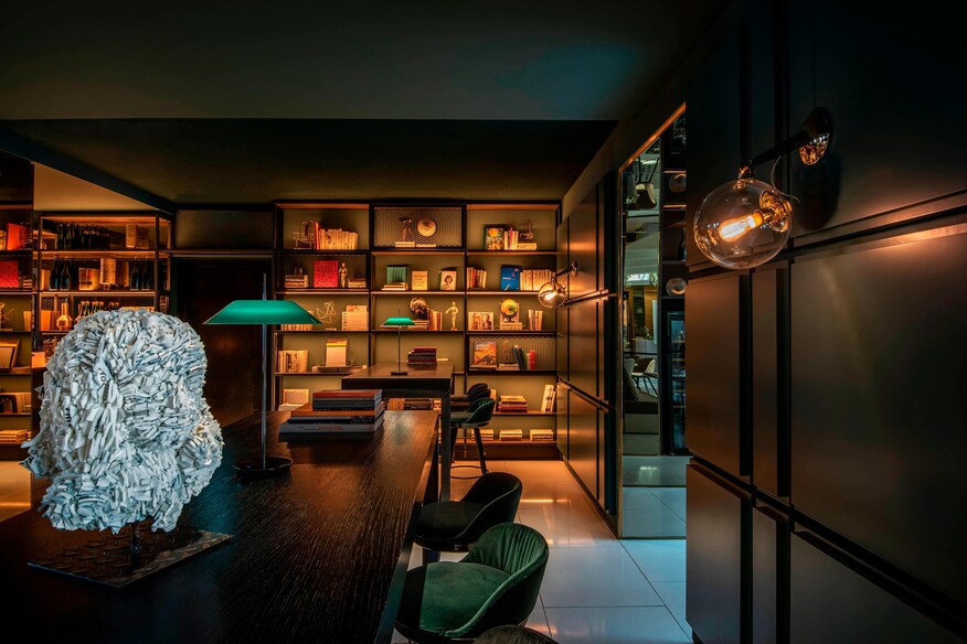 Hotel library with art, green accents, and seating