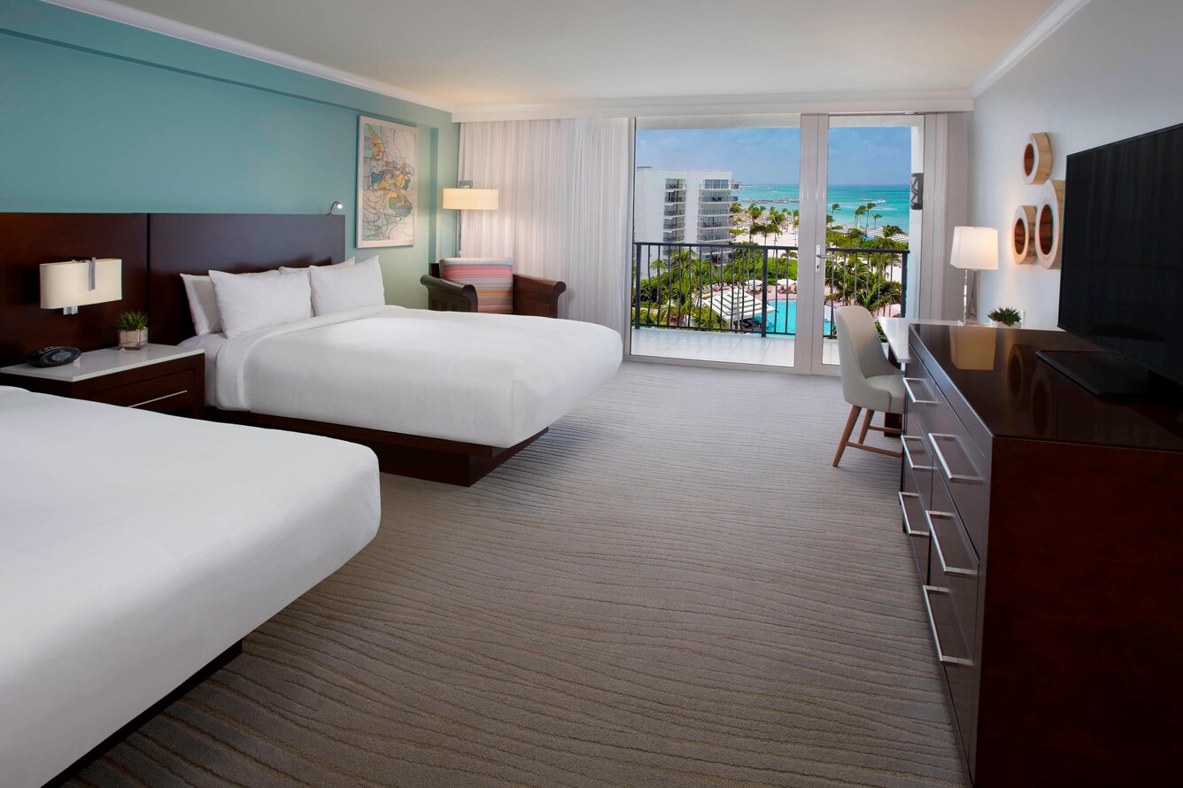Guestroom with two queen beds and view of the extra large balcony.