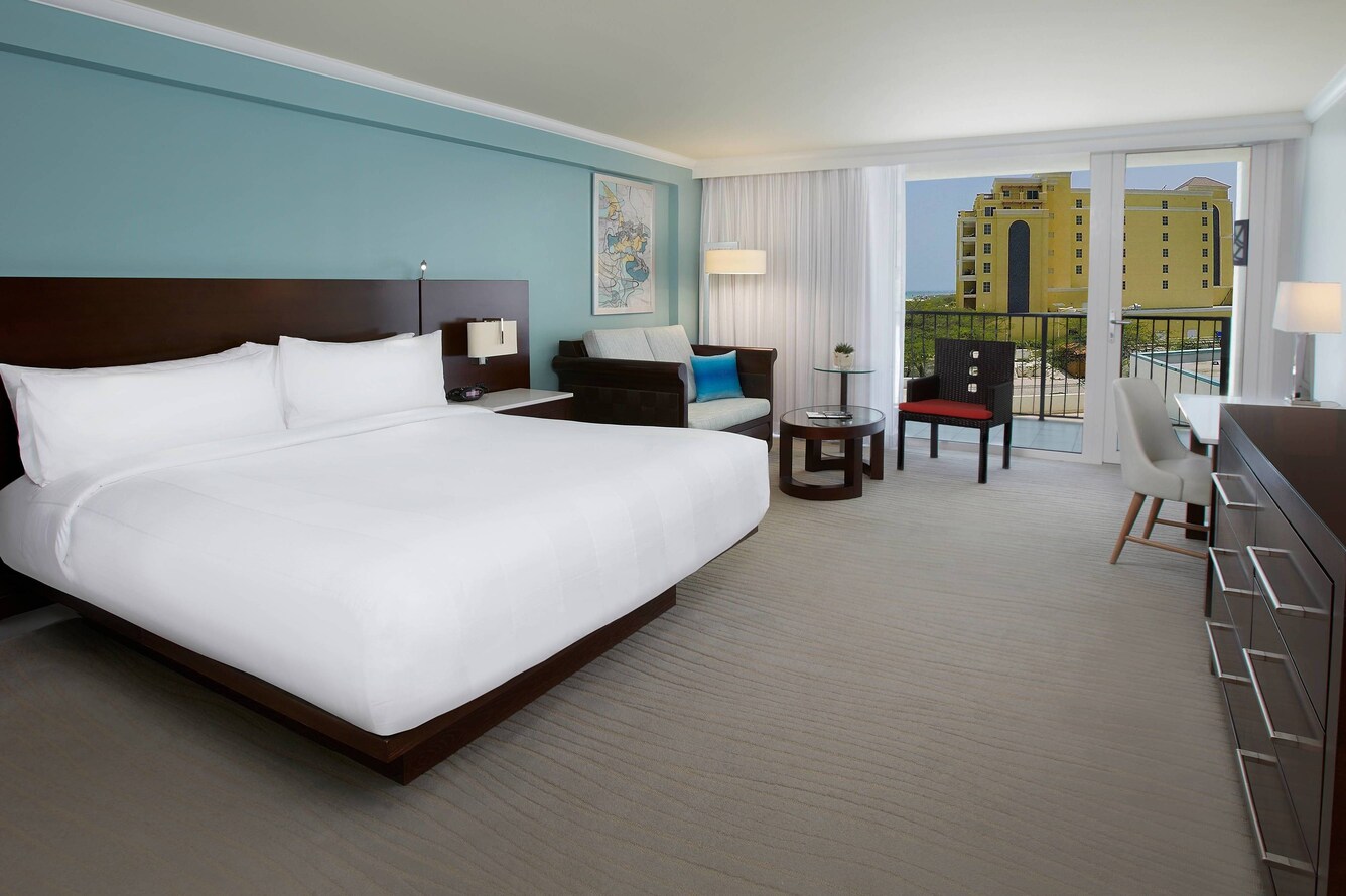 Guestroom with a single king bed and view of a hotel.