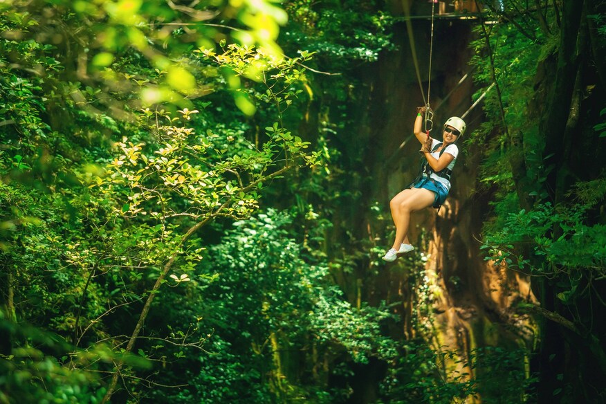 Woman ziplining through forest