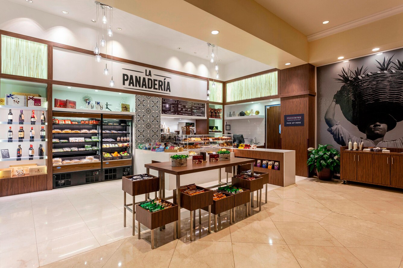 Convenience store area with shelves and goods in lobby.