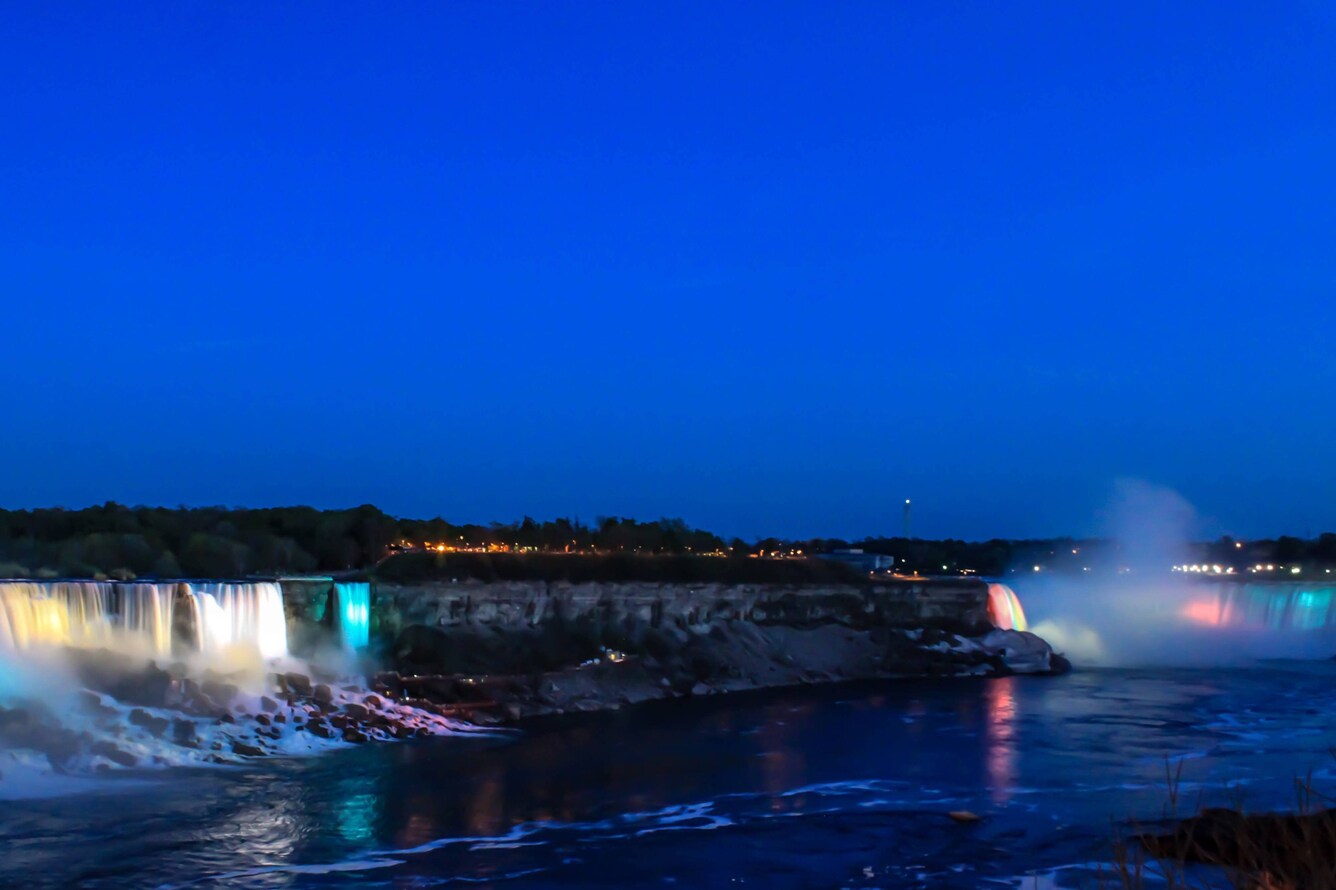 Niagara Falls illuminated with different colors at night