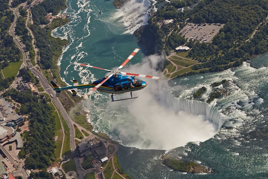 Blue helicopter flying over Niagara Falls.