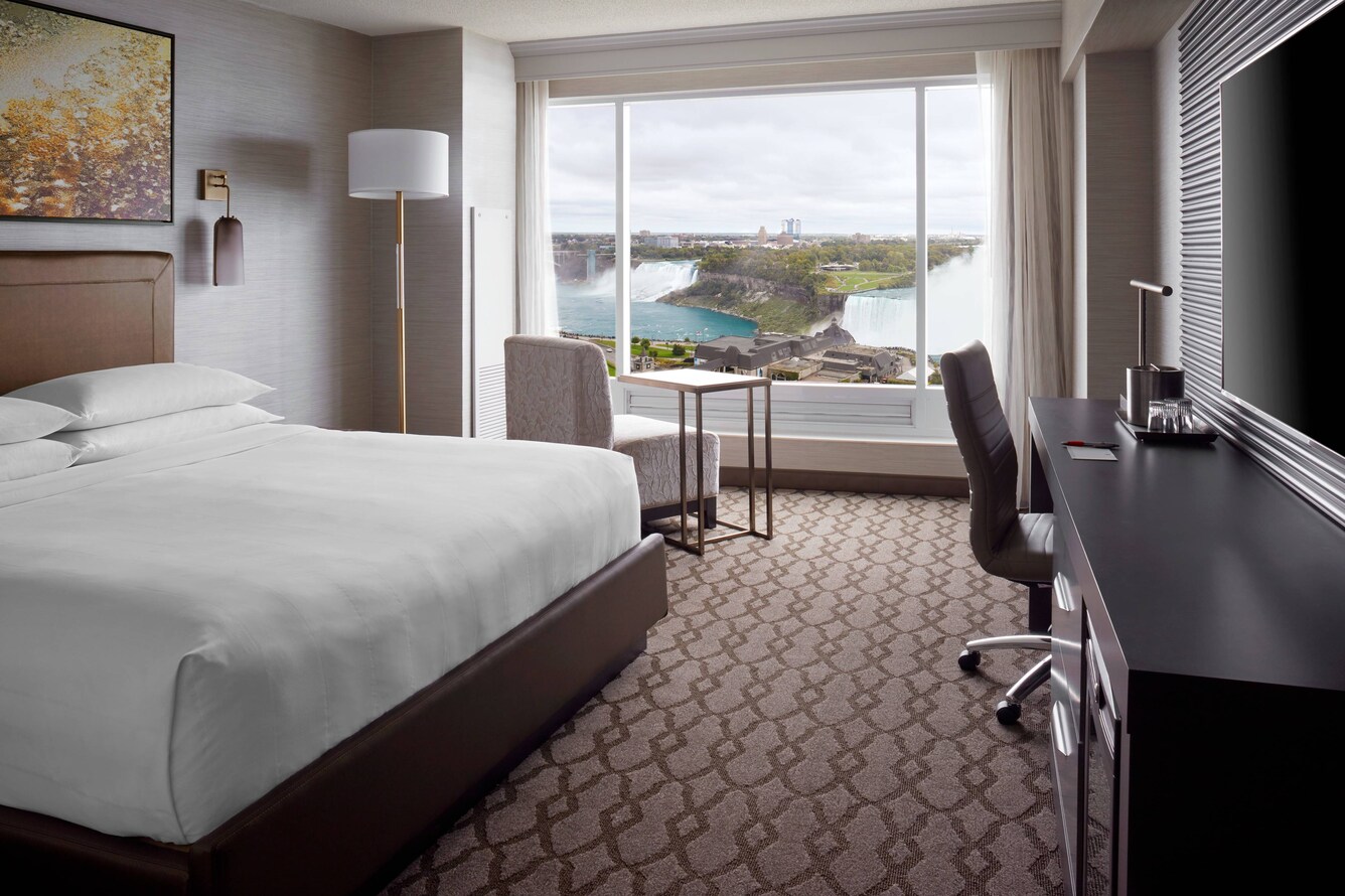queen bed in room overlooking falls