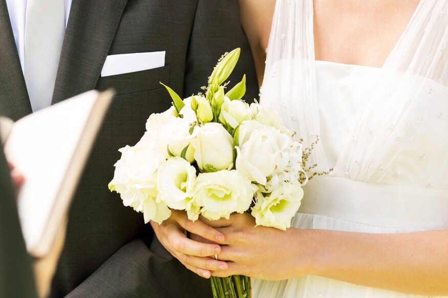 A close up of couple and bride's flowers