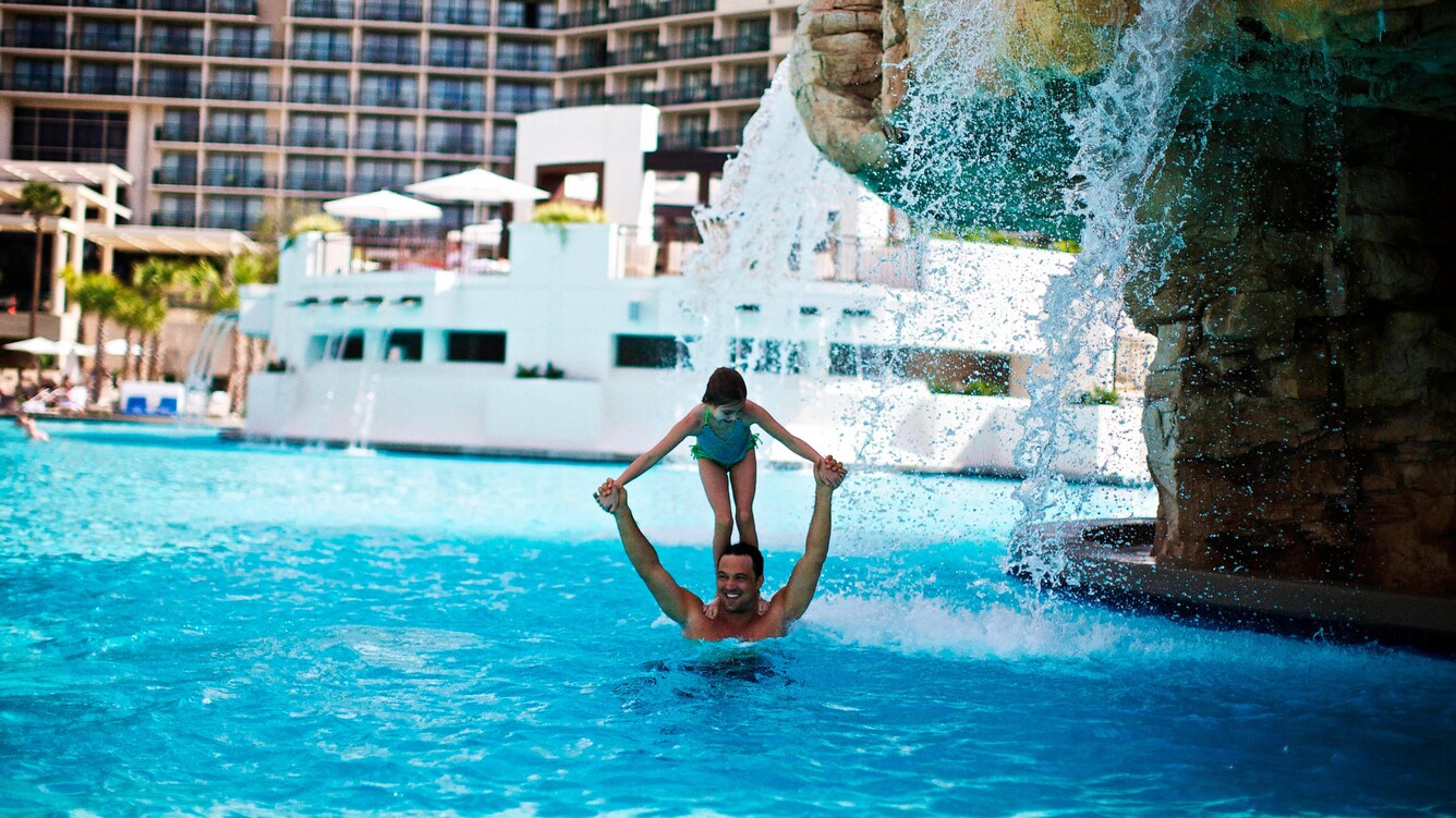 father playing with child under water feature