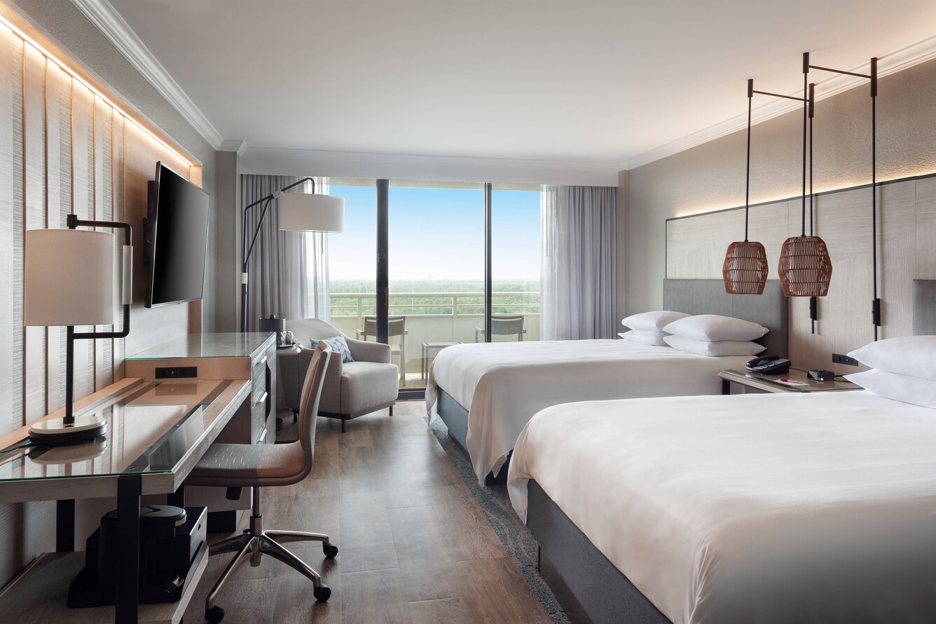 two queen beds with balcony in the background