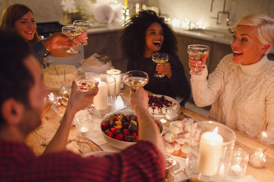 A group of friends sitting at a dinner table engaged in a toast.