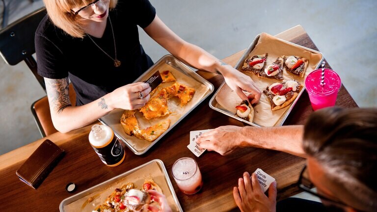 People sitting and eating communal share dishes