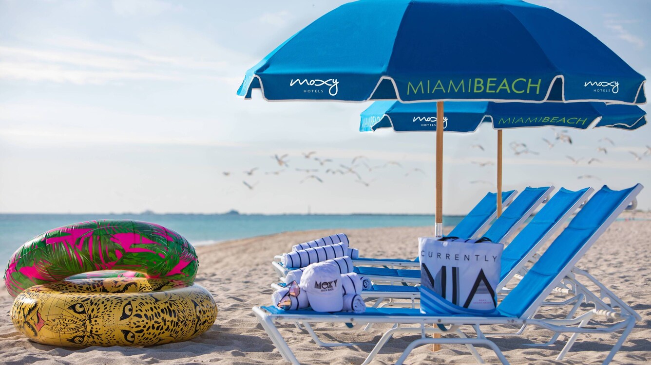 Miami beach lounge chairs, umbrellas, and multicolored pool inner tubes