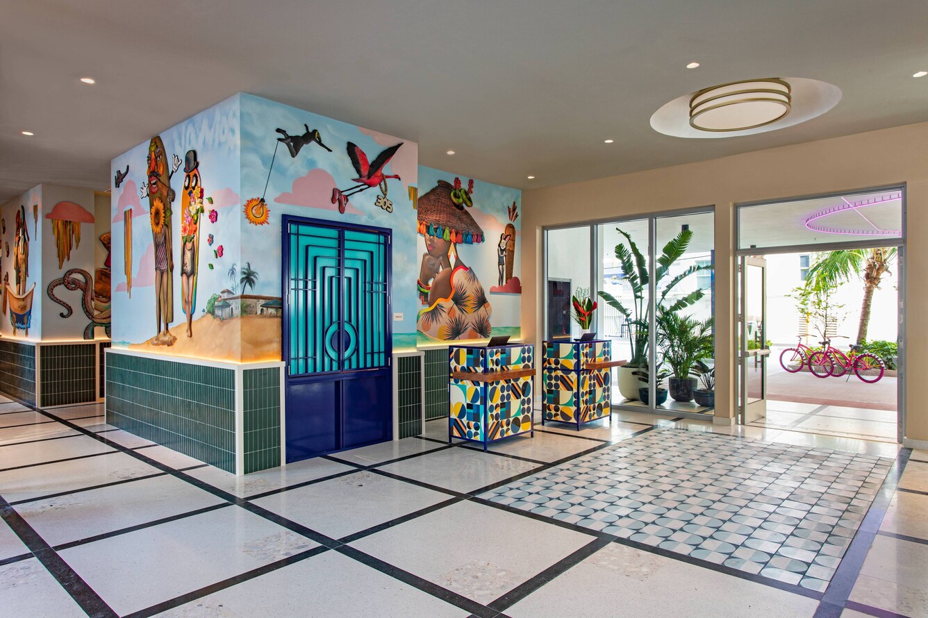 Check in desk with brightly colored mural in moxy miami lobby