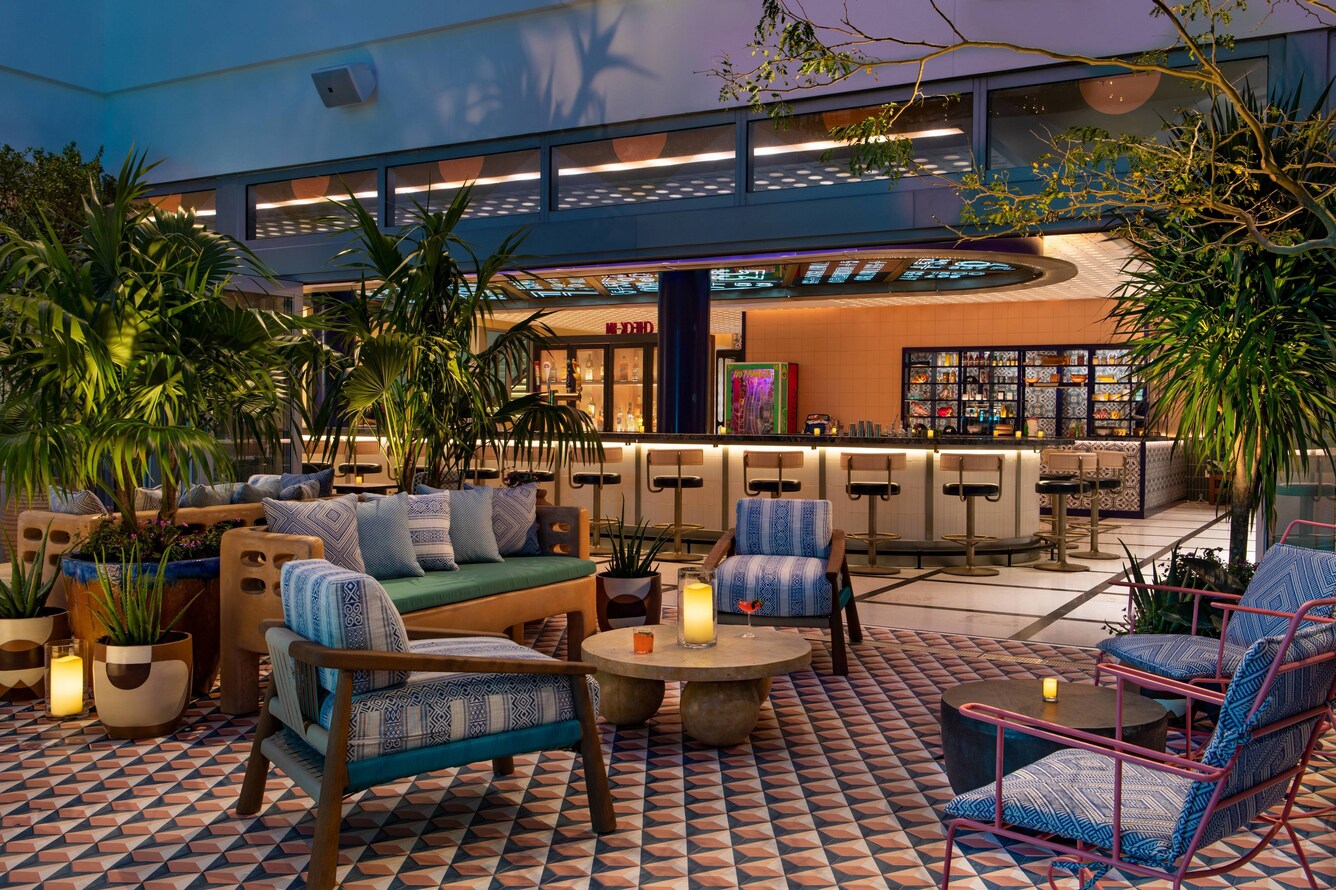 Alfresco courtyard lounge seating at night with candles at moxy miami south beach.