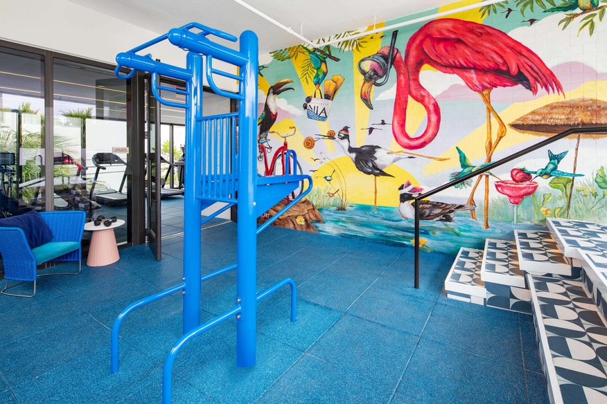 Moxy miami indoor outdoor gym with wall mural, blue decor, and pullup bar