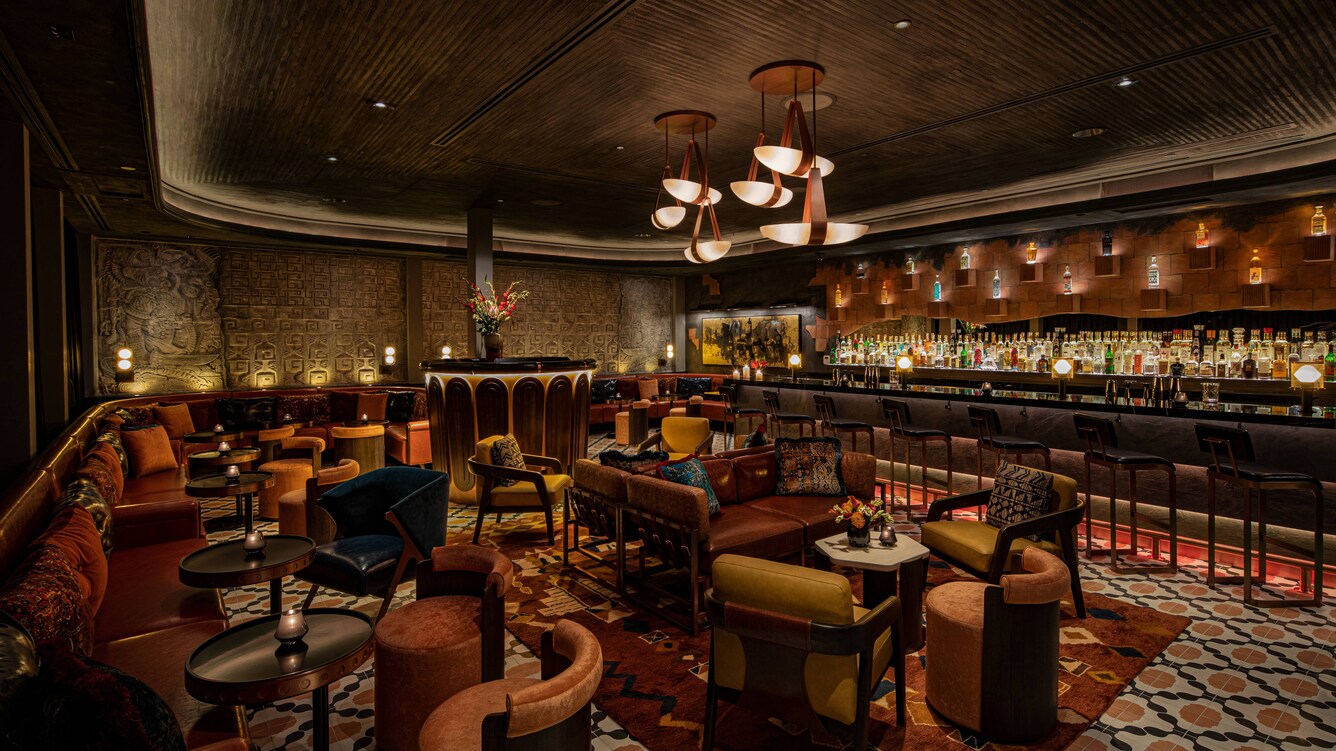 Dimly-lit brown and yellow decorated bar with diamond carpets.