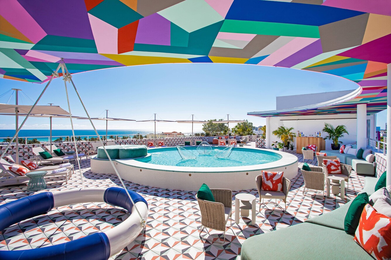 Rooftop lounge with multicolored shading, lounge pool, and hanging tire swing