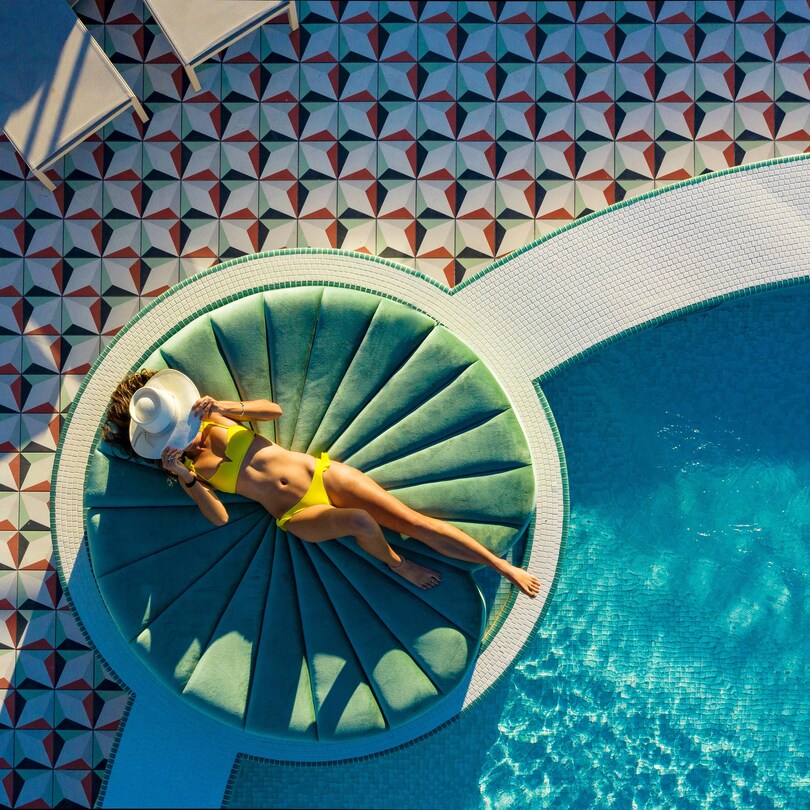 Woman lounging on the upside day pool lilly pad day bed