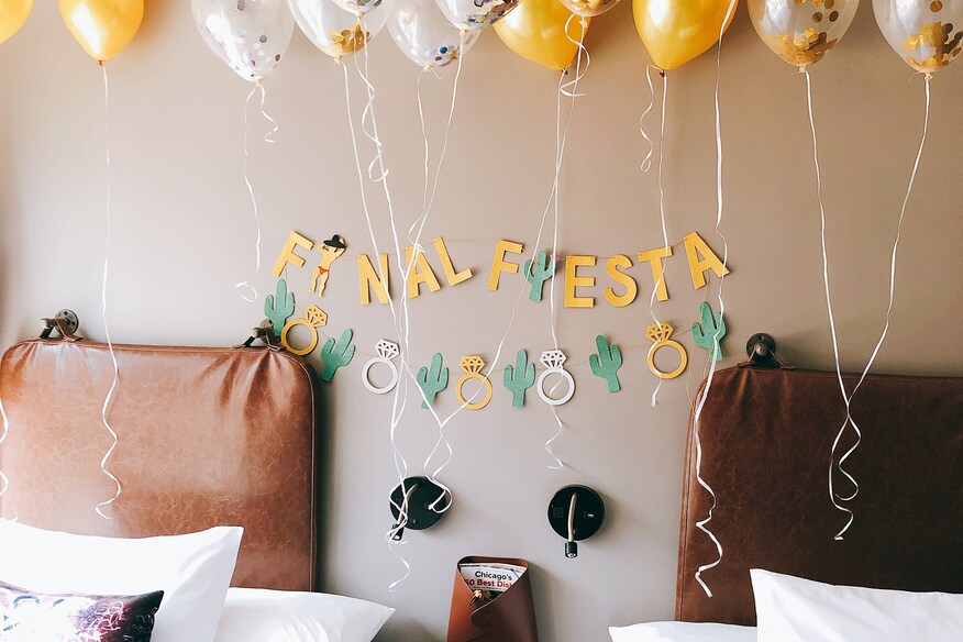 green and yellow party decorations with balloons and paper cutouts that spell "Final Fiesta"