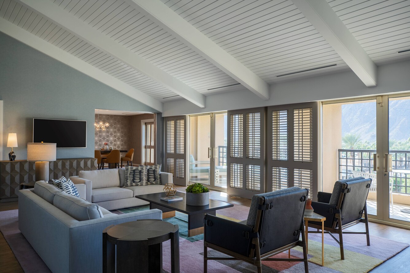 Living room seating, wall mounted tv and sliding glass door access to the patio.