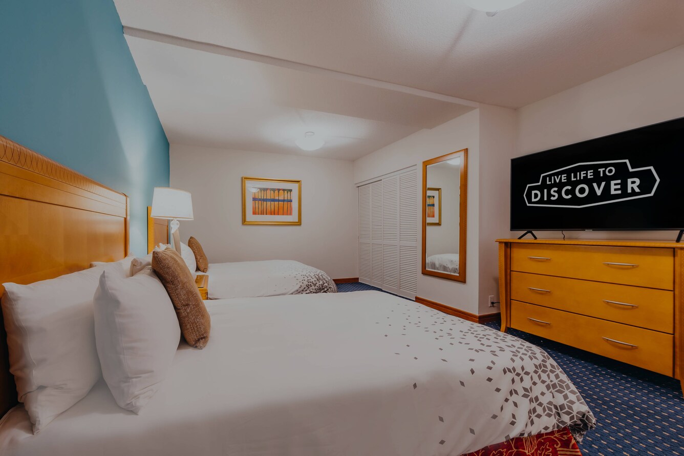 Bedroom with two double beds and TV