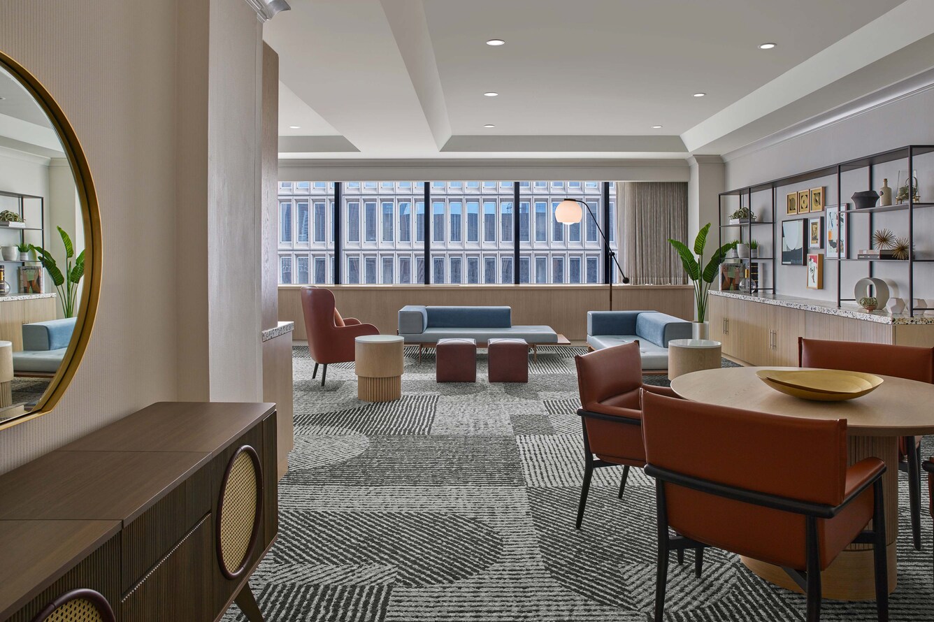 Suite living area with window overlooking city.