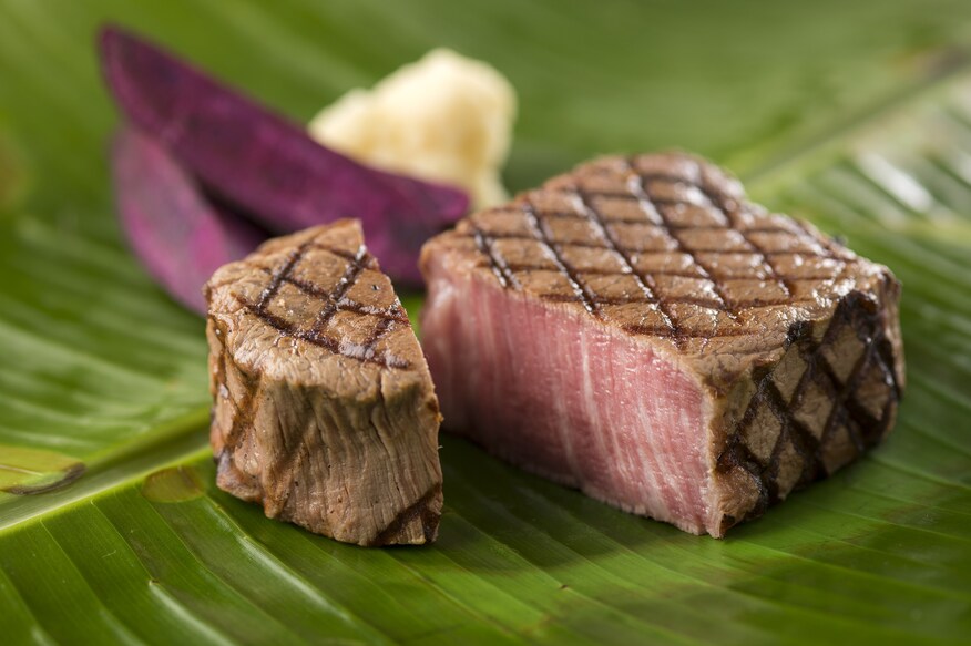 A grilled steak cut into two pieces.