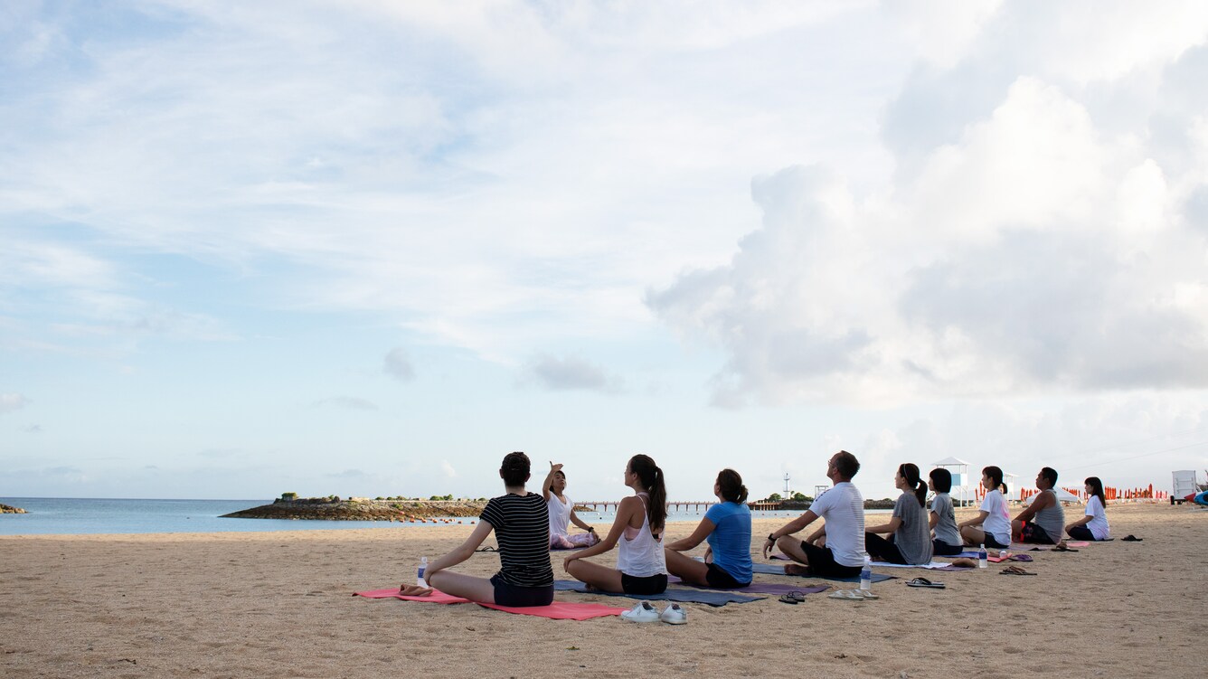 Group participating in morning yoga class on the beach