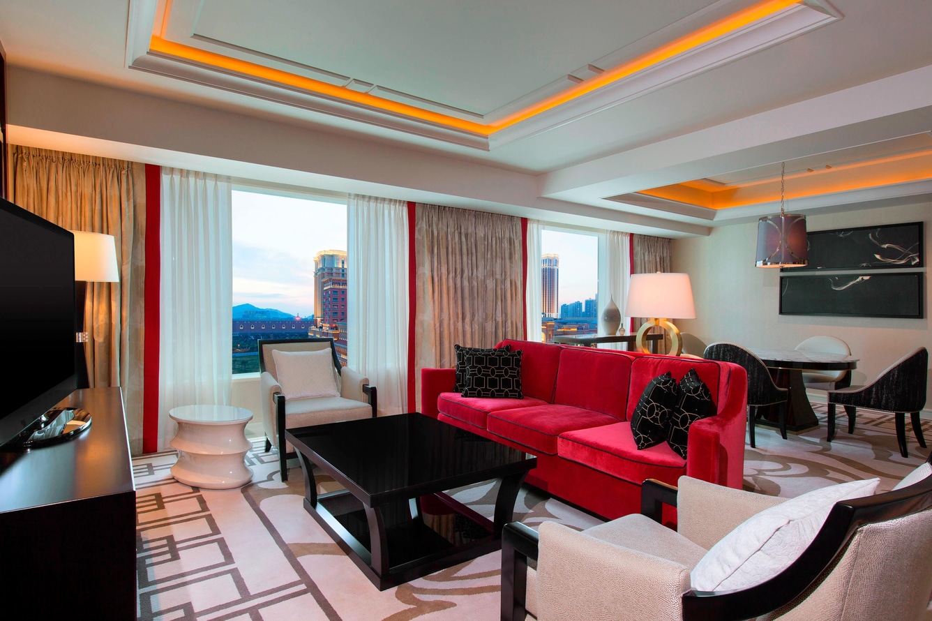 Deluxe suite club access living area with dining area and red couch