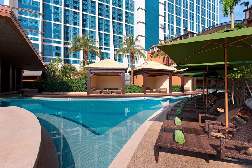 Sala pool cabana with poolside lounge chairs and green umbrellas