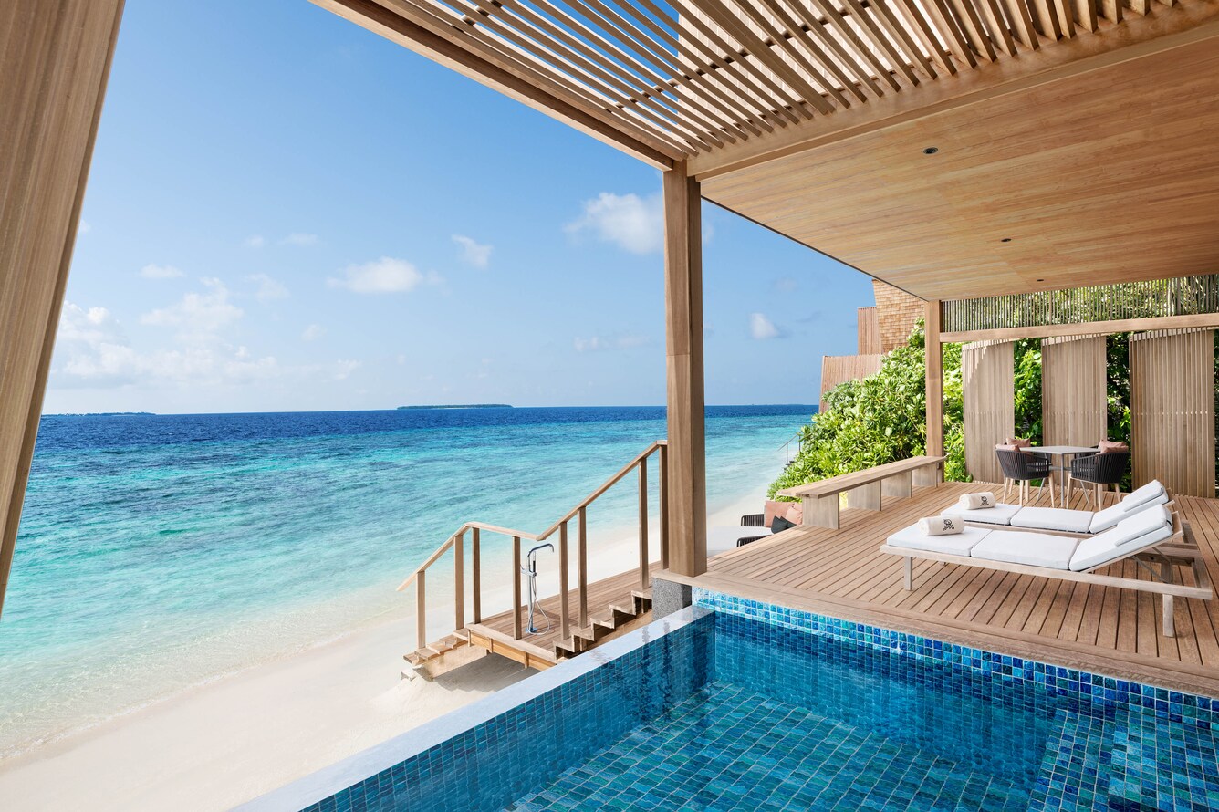 Small plunge pool covered with awning, deck with staircase that ascends down to the beach and Ocean