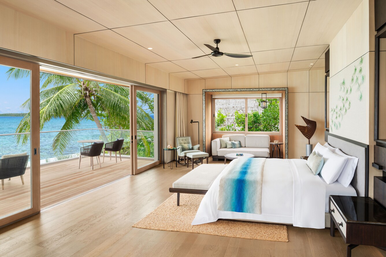 Open concept room with Double bed and full wall doors that open onto a deck