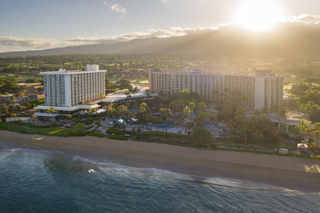 Hotel exterior and beach at sunset.