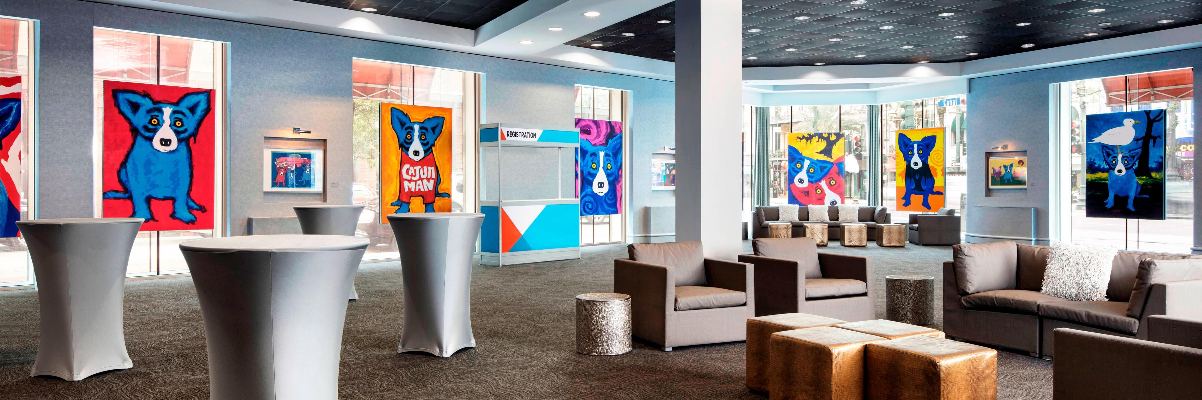 Art gallery with ofas, armchairs, and tables.