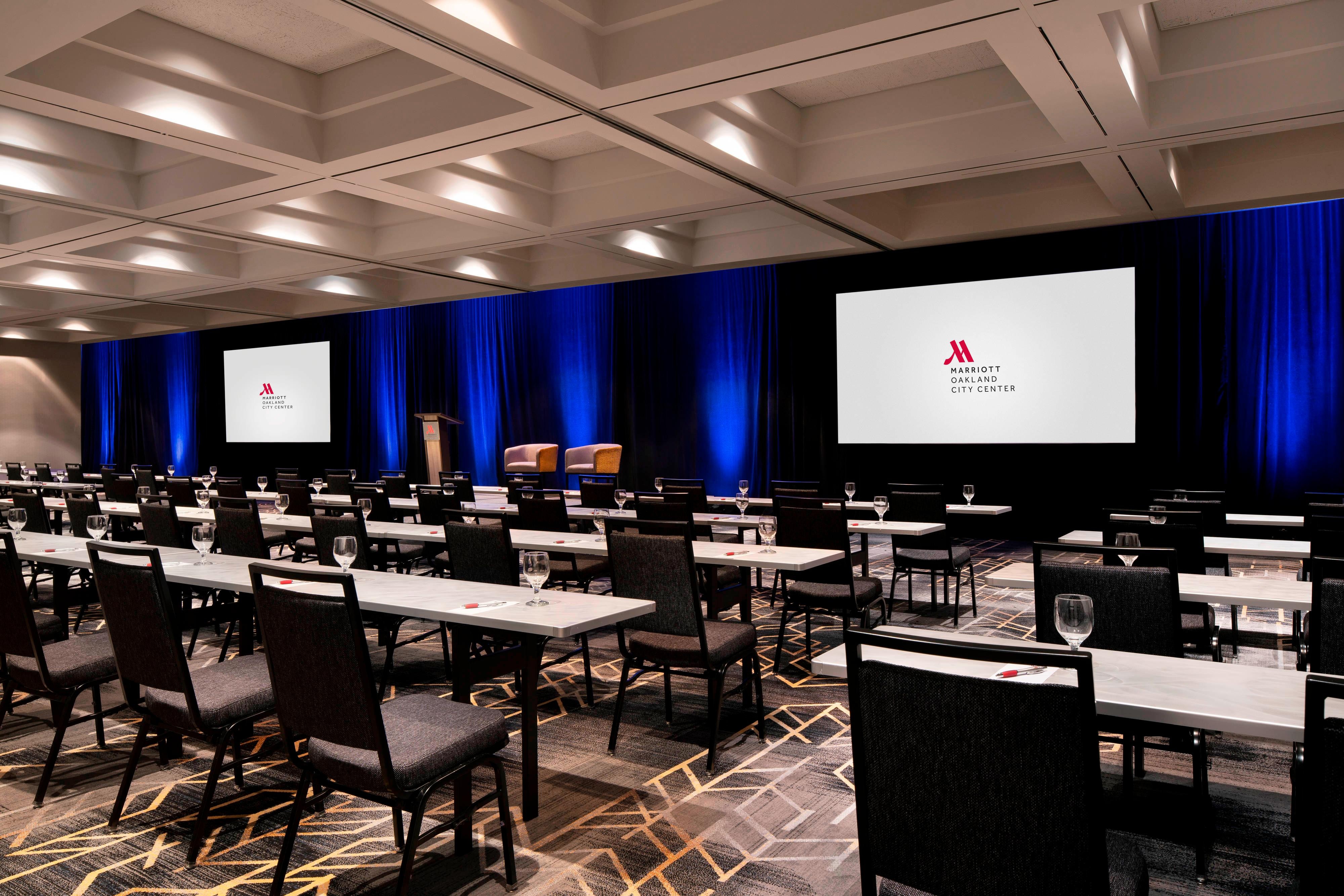 Junior Ballroom set up for classroom meeting with long tables lined with chairs