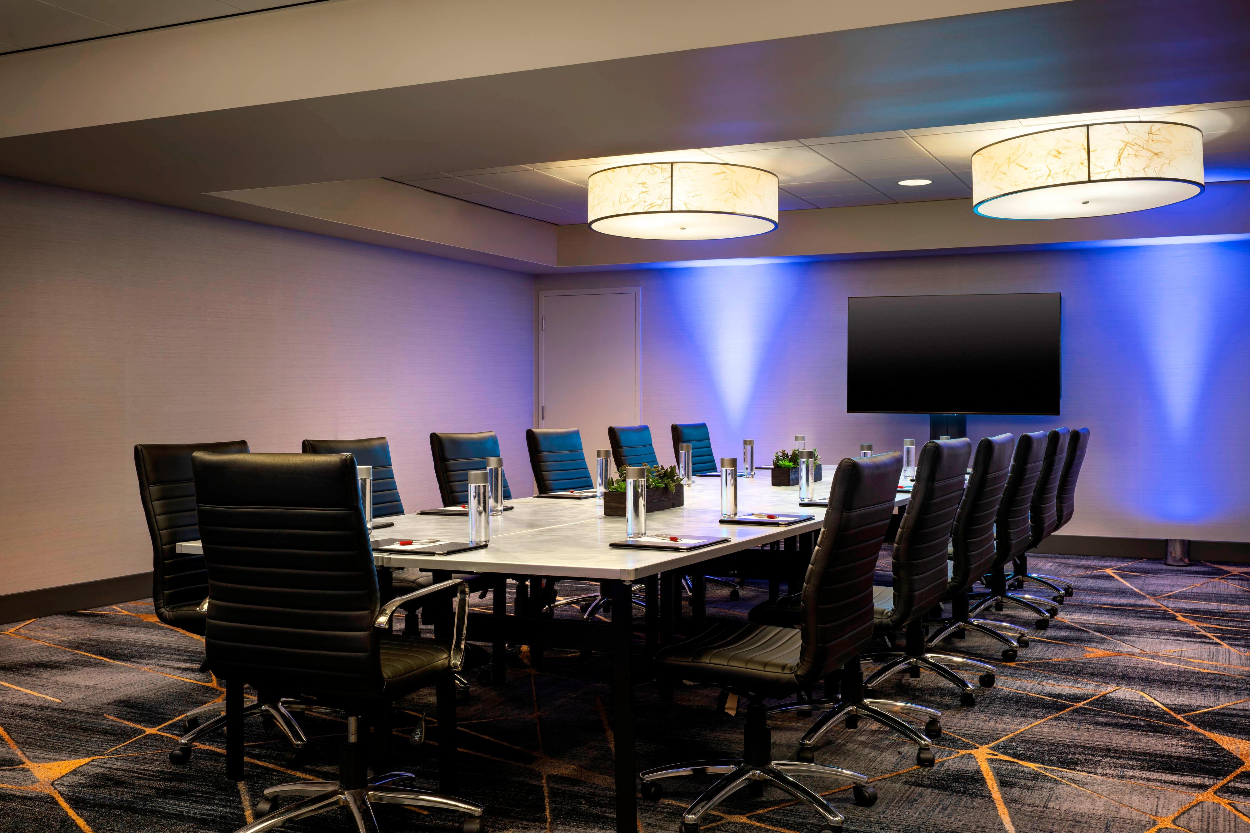 California Meeting Room with long table, swivel chairs, and flatscreen display