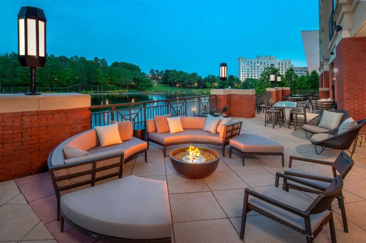 Outdoor courtyard seating around a firepit at dusk.